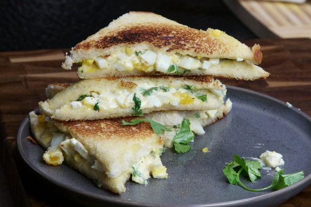 Uma pilha de pão e salada de ovo com sanduíche de maionese em uma bandeja
 - Foto, Imagem