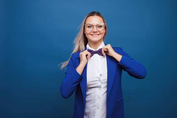 Happy smiling young woman in blue on blue background. Friendly business portrait - Fotó, kép