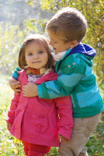 Bruder umarmt Schwester im Herbstpark - Foto, Bild