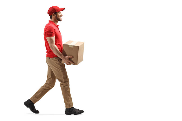 Delivery man carrying a package and walking  - Φωτογραφία, εικόνα