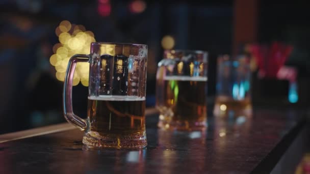 Detalles de primer plano forman un pub dos vasos de cerveza de pie sobre una mesa de bar tomando el vídeo de cerca de la cámara en un bar moderno
 - Metraje, vídeo