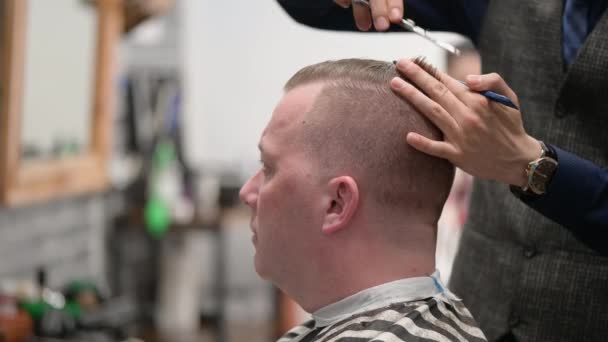 Corte de cabelo dos homens na Barbearia. Close-up de mestre cortando um homem com cabelo loiro com tesoura
 - Filmagem, Vídeo
