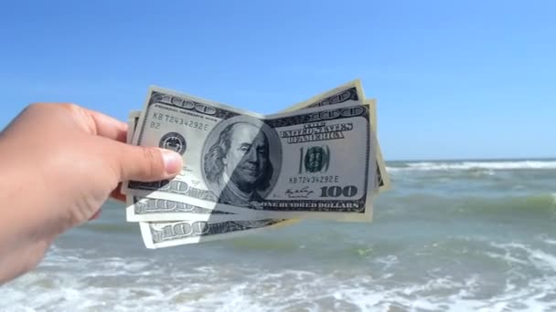 Man holds three hundred dollar banknotes in his hands on a background - Felvétel, videó