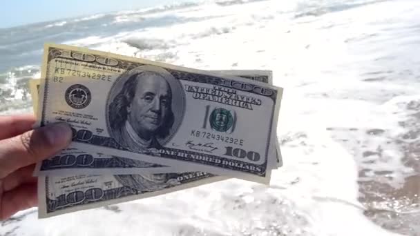 El hombre sostiene trescientos billetes de dólar en sus manos sobre un fondo
 - Metraje, vídeo