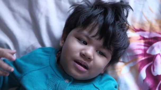 bovenaanzicht van baby kind liggend op bed en huilend  - Video