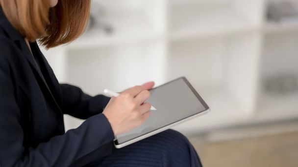 Vista laterale della donna d'affari che scrive su tablet schermo bianco con stilo
  - Foto, immagini