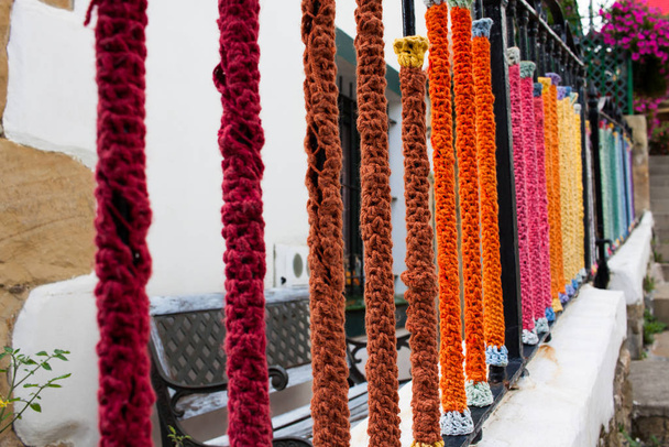 cerca de metal ralado forrado com lã colorida na casa da aldeia
 - Foto, Imagem