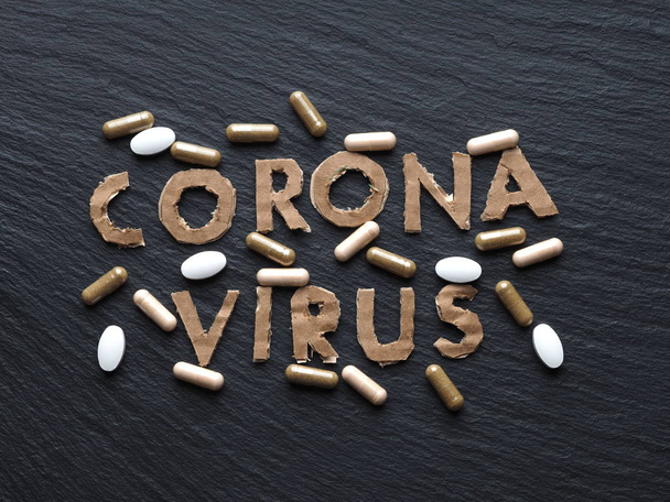 Коронавирусная картонная текстовая фраза на черном фоне с лекарствами New 2019-nCoV, MERS-Cov New Coronavirus
. - Фото, изображение