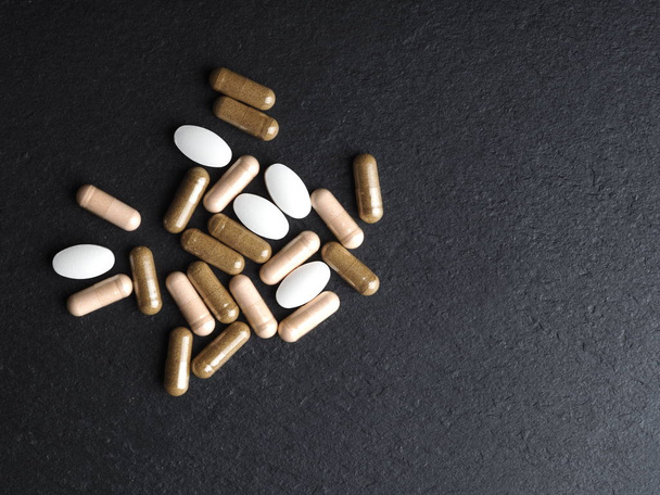 таблетки и капсулы с медициной крупным планом на черном фоне, Новый Коронавирус 2019-nCoV, MERS-Cov
. - Фото, изображение