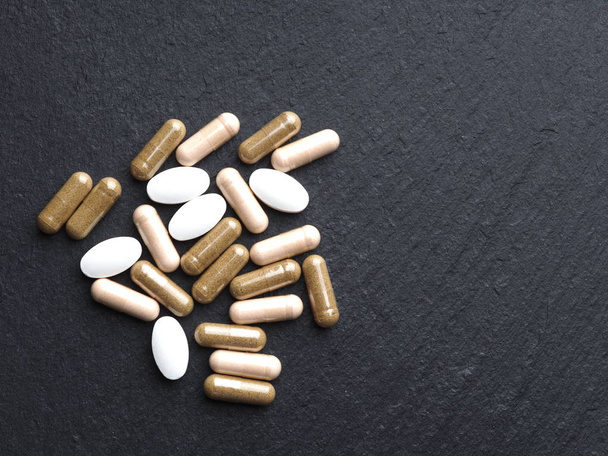 tabletták és kapszulák gyógyszerrel közelről fekete alapon, Új Coronavirus 2019-ncov, Mers-Cov. - Fotó, kép