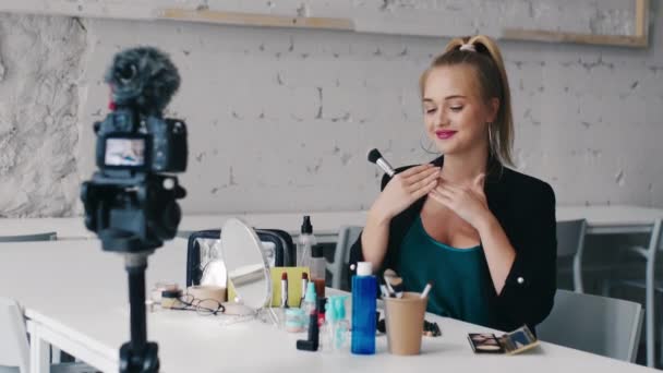 Atractivo blogger belleza mostrando felizmente productos cosméticos grabación maquillaje tutorial video para internet
 - Imágenes, Vídeo
