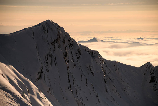 Pohled na zasněžený vrchol hory při západu slunce - Fotografie, Obrázek