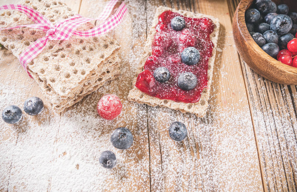Decorated sweet breakfast with berries and toast over wooden table. Tasty healthy food  - Фото, изображение