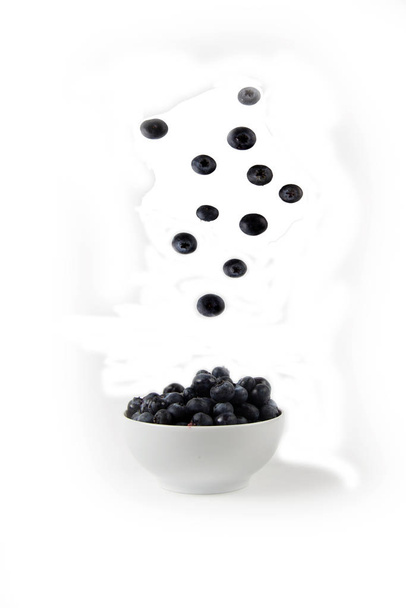 blueberry pouring into a bowl on white background - Foto, Imagem
