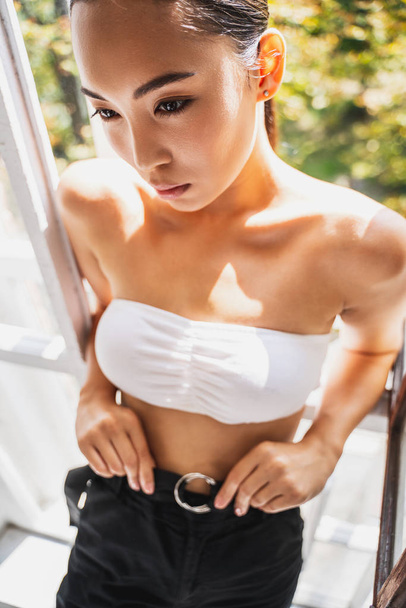 Cute Asian female leaning on window frame - Zdjęcie, obraz