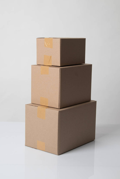 Pile of various size taped up  cardboard boxes - Zdjęcie, obraz