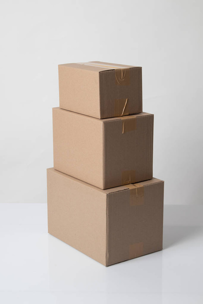 Pile of various size taped up  cardboard boxes - Foto, Imagen