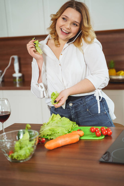 Mujer regordeta alegre preparando su ensalada favorita
 - Foto, Imagen