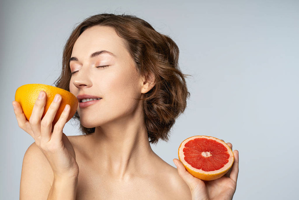 Positive delighted young woman enjoying citrus aroma - Valokuva, kuva