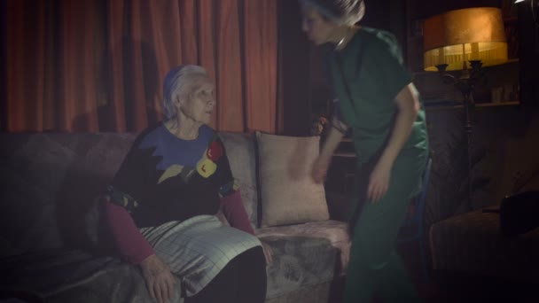 Medische zorg voor oma thuis.Een gezondheidswerker komt naar het huis van een bejaarde vrouw en is geïnteresseerd in haar gezondheidstoestand. - Video