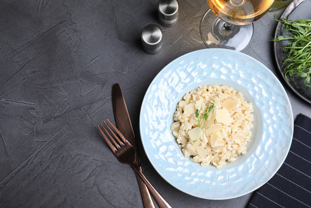 Delicious risotto with cheese on grey table, flat lay. Space for text - Фото, зображення