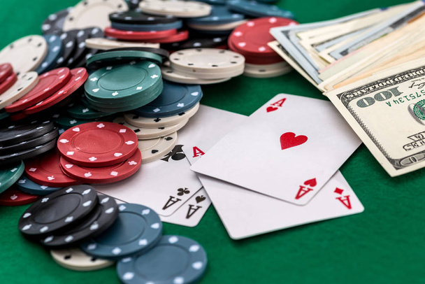 Покерные фишки, карты и доллары на зеленом фоне
 - Фото, изображение