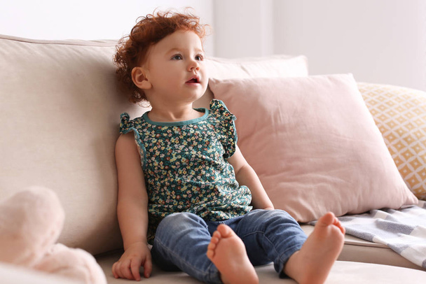 Portrait of cute little child on sofa at home - Fotó, kép
