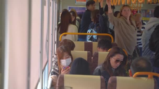 Kobe, Japan - NOV 05, 2019 - People seated in JR Kobe Line train car in 4k - Materiaali, video