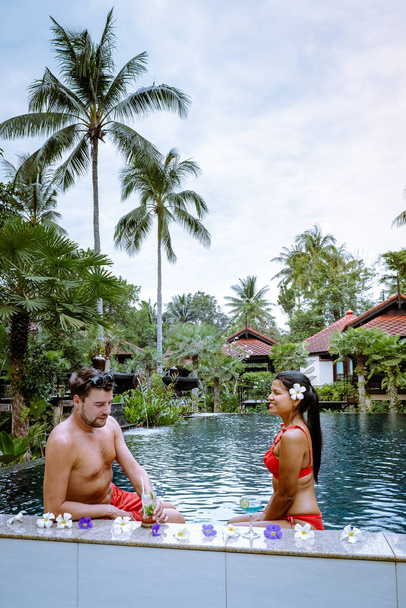 pareja bebiendo cócteles en la piscina durante las vacaciones en Tailandia - Foto, Imagen