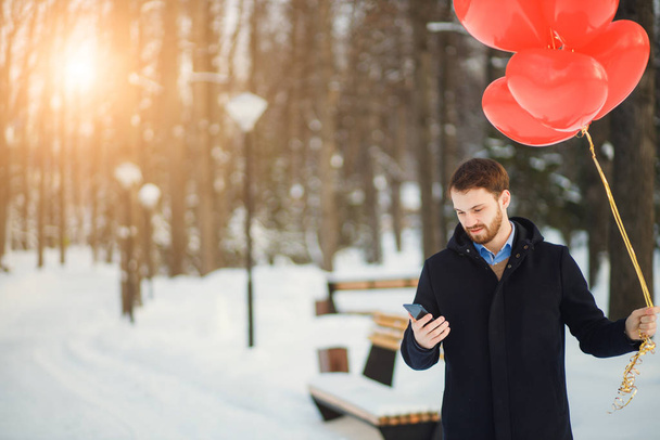 bearded romantic guy with red air ballons outdoors - Photo, image