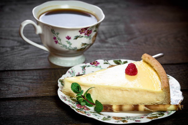 Snijd van heerlijke cheesecake en kopje koffie - Foto, afbeelding