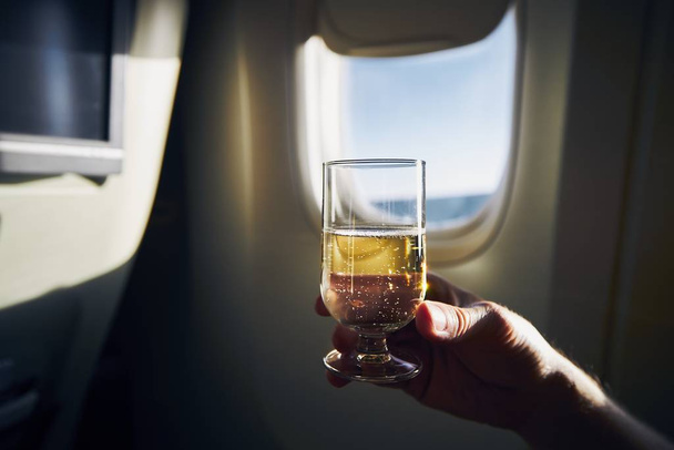Glass of sparkling wine during flight - Foto, Imagen