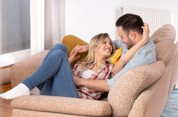 junges Paar in Umarmung auf dem Sofa - Foto, Bild