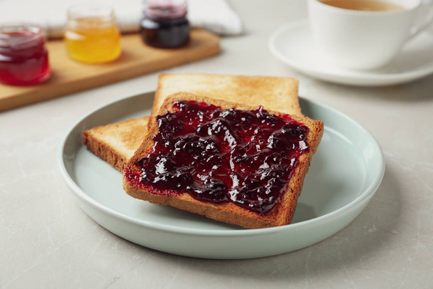 Delicious crispy toasts with jam on table - Фото, зображення