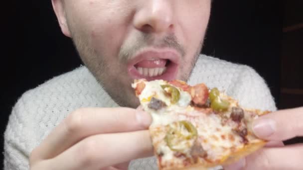 Detail muž jí pizzu na černém pozadí - Záběry, video