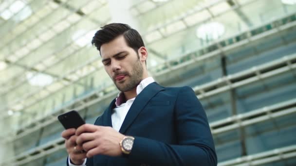 Portrait homme d'affaires utilisant un smartphone. Homme debout avec téléphone à la main à l'extérieur
 - Séquence, vidéo
