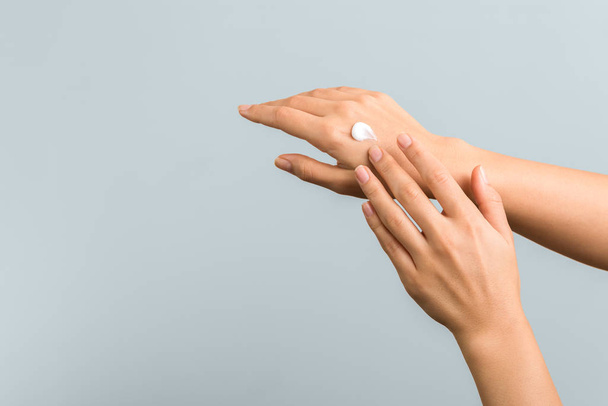 healthy hands and nails. seasonal skin protection. woman applying moisturizer on her hands - Valokuva, kuva