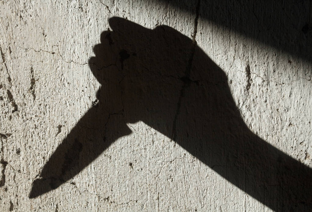 Shadow of the hand holding a knife - 写真・画像
