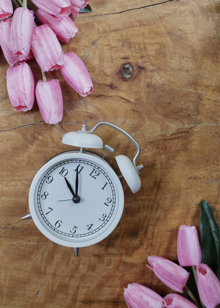 Tulipanes morados con despertador en madera
 - Foto, imagen