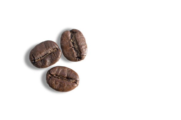 白い背景にコーヒー豆がいくつかあります。マクロ写真 - 写真・画像