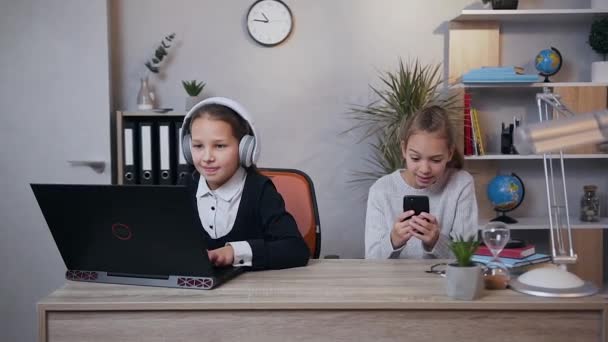 Όμορφα συναρπαστικά έφηβα κορίτσια που παίζουν βιντεοπαιχνίδι σε φορητό υπολογιστή και τηλέφωνο ταυτόχρονα και γιορτάζουν τη νίκη - Πλάνα, βίντεο