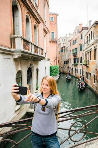 Νεαρή γυναίκα ταξιδιώτης που παίρνει μια selfie από το κανάλι στη Βενετία, Ιταλία - Φωτογραφία, εικόνα