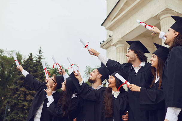 Scrolls diplomas in the hands of graduates. - Foto, Imagem