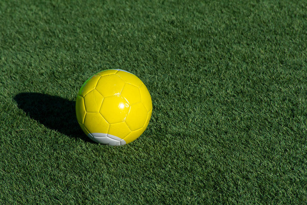Billard de football jaune vif ou ballon de piscine sur herbe verte avec un espace ombre et copie. Concept de sport, de loisirs et de plaisir de l'enfance
. - Photo, image