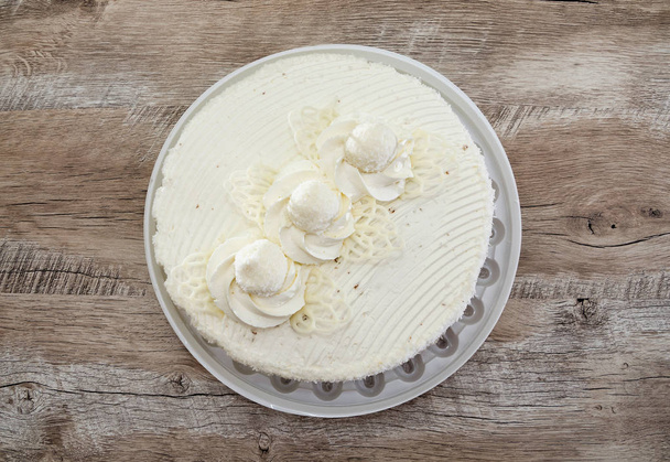 Ahşap arka planda kremalı lezzetli, beyaz bir pasta. Yukarıdan görüntüle. - Fotoğraf, Görsel