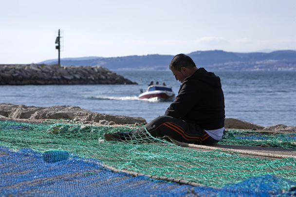 Marinheiro fixou suas redes de pesca no porto de Estepona
 - Foto, Imagem