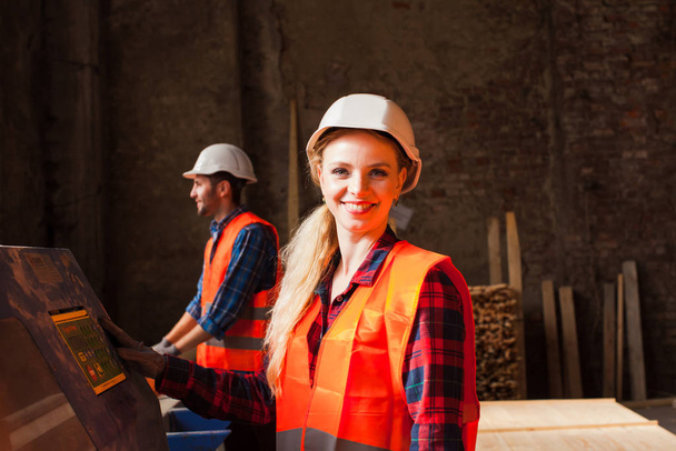 Portrait of attractive hardworking professional female carpenter worker in the workshop. - Фото, зображення