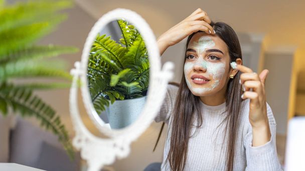 Great skin that makes you smile. Woman with a mask on her face. Spa Woman applying Facial clay Mask. Beauty Treatments. Close-up portrait of beautiful girl with applying facial mask - Photo, Image