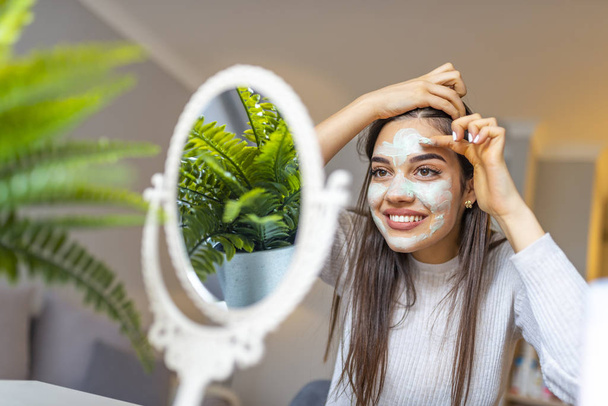 Spa Woman applying Facial clay Mask. Beauty Treatments. Close-up portrait of beautiful girl applying facial mask. Spa teen girl applying facial clay mask. Beauty treatments. - Φωτογραφία, εικόνα