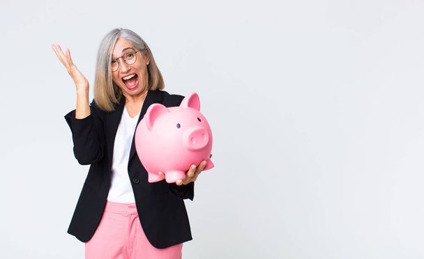 middle age woman with a piggy bank. savings concept - Zdjęcie, obraz